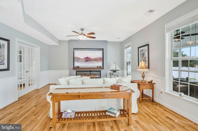 455 Creeks End Ln, Stevensville, MD 21666 - living room with light wood-type flooring, wainscoting, healthy amount of natural light, and a ceiling fan