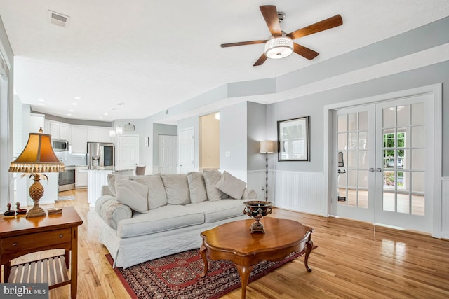 455 Creeks End Ln, Stevensville, MD 21666 - living room with light wood-style flooring, ceiling fan, french doors, and wainscoting