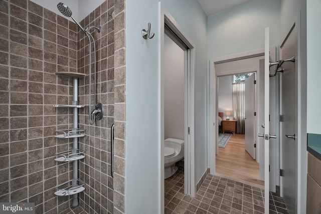 bathroom featuring a tile shower and toilet
