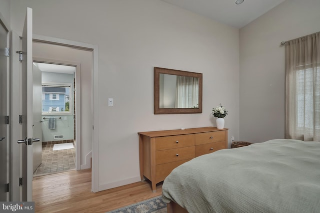 bedroom with light wood-type flooring and baseboards