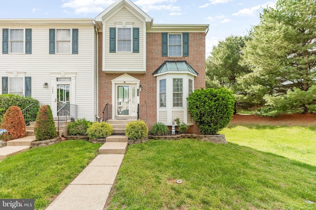 multi unit property with a front yard and brick siding