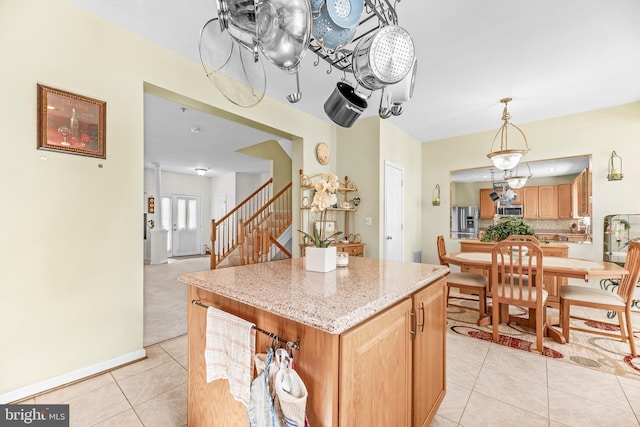 kitchen featuring appliances with stainless steel finishes, light tile patterned flooring, decorative backsplash, a center island, and pendant lighting