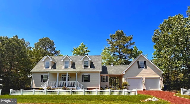 119 Mumfords Landing Rd, Ocean Pines, MD 21811 - cape cod home featuring covered porch, a fenced front yard, a garage, roof with shingles, and driveway