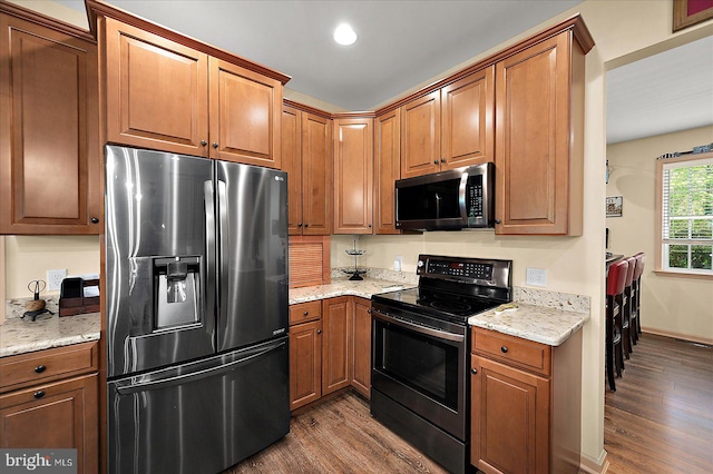 119 Mumfords Landing Rd, Ocean Pines, MD 21811 - kitchen with appliances with stainless steel finishes, dark wood-style flooring, light stone countertops, brown cabinetry, and recessed lighting