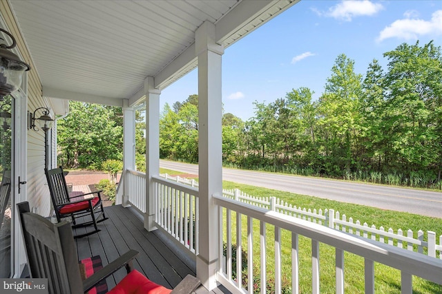 119 Mumfords Landing Rd, Ocean Pines, MD 21811 - deck featuring covered porch, fence, and view of scattered trees