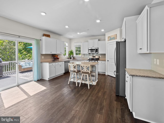 1422 Silver Oak Ln, Arnold, MD 21012 - kitchen with stainless steel appliances, white cabinetry, tasteful backsplash, dark wood-style flooring, and light stone countertops