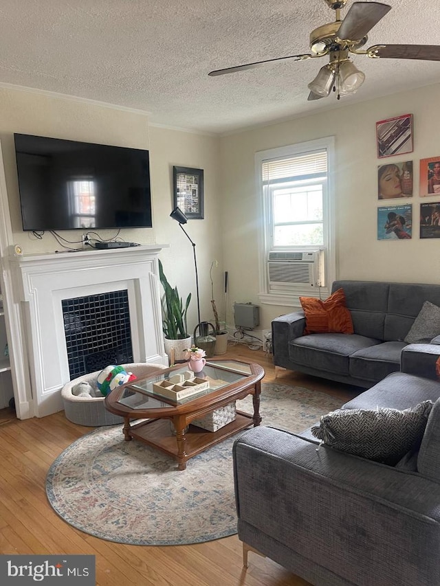 138 W 4th St, Bridgeport, PA 19405 - living area with cooling unit, wood finished floors, a textured ceiling, a tiled fireplace, and ceiling fan
