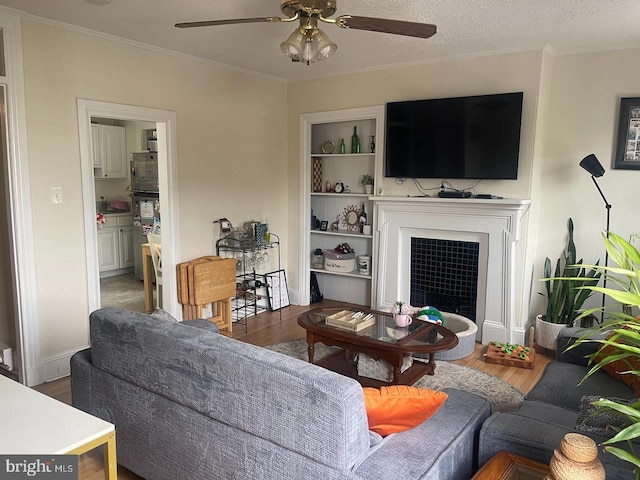 138 W 4th St, Bridgeport, PA 19405 - living area featuring a ceiling fan, crown molding, wood finished floors, a fireplace with flush hearth, and baseboards