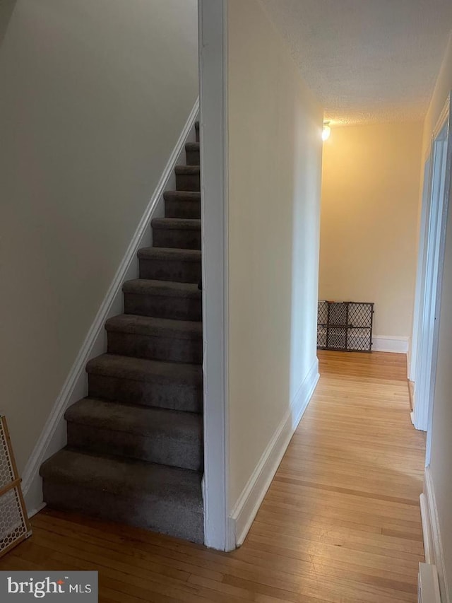138 W 4th St, Bridgeport, PA 19405 - stairs featuring wood finished floors, baseboards, and a baseboard heating unit