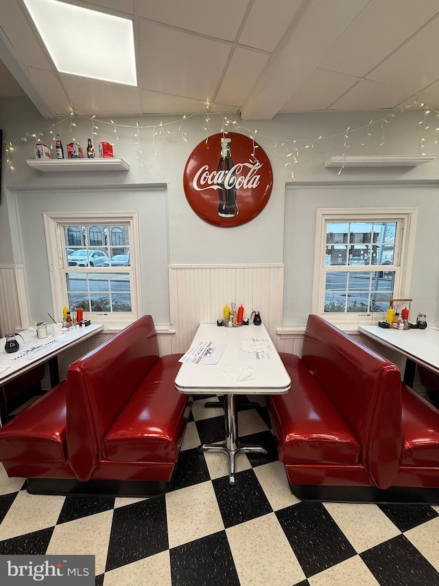 138 W 4th St, Bridgeport, PA 19405 - dining area featuring tile patterned floors, wainscoting, a paneled ceiling, and track lighting