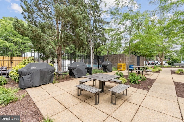 view of patio / terrace with a grill, outdoor dining space, and fence