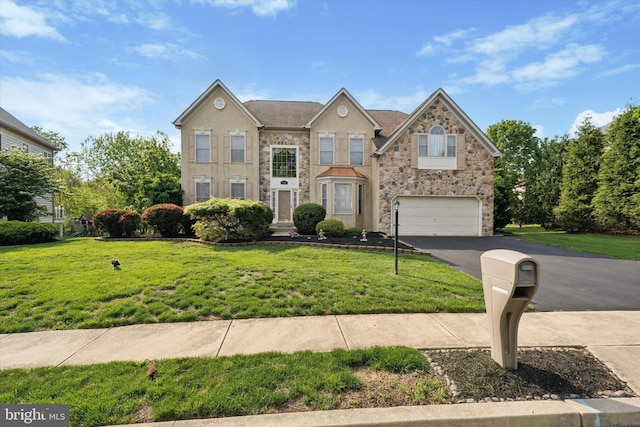colonial inspired home featuring stone siding, driveway, a garage, and a front lawn