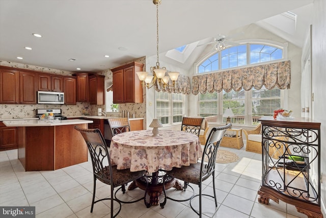 dining room with light tile patterned floors, a chandelier, a skylight, recessed lighting, and vaulted ceiling