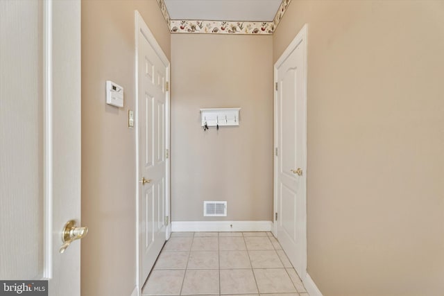 corridor featuring light tile patterned floors and baseboards
