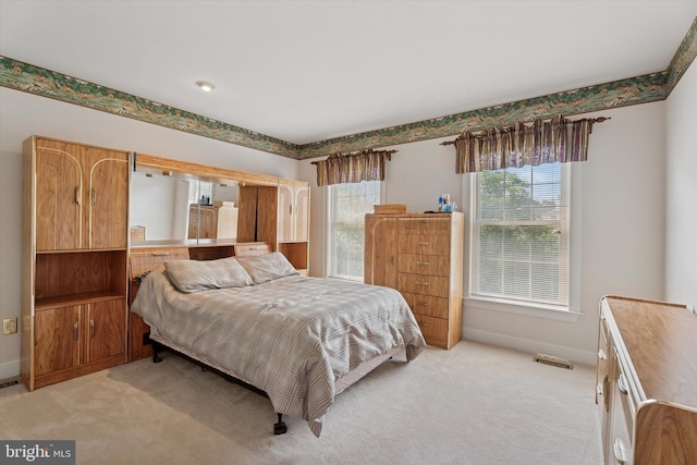 bedroom featuring light carpet and baseboards