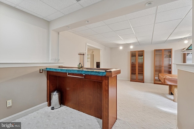 bar featuring a drop ceiling, carpet, and baseboards