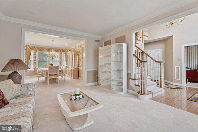 carpeted living room featuring a chandelier, stairs, crown molding, and baseboards