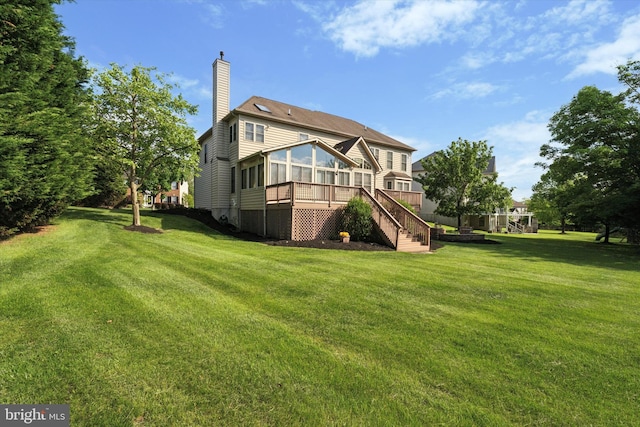 back of property with a sunroom, a chimney, a yard, and stairway