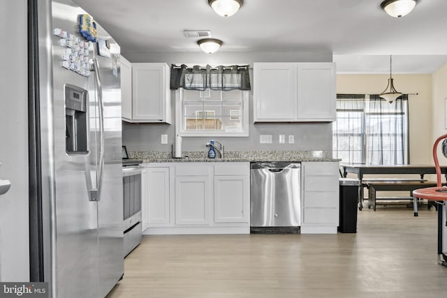 39 Baltic Ct, Inwood, WV 25428 - kitchen with stainless steel appliances, light stone counters, white cabinetry, and light wood-style flooring