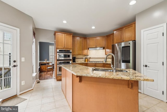 10611 Tattersall Dr, Manassas, VA 20112 - kitchen featuring appliances with stainless steel finishes, a sink, light tile patterned flooring, under cabinet range hood, and backsplash