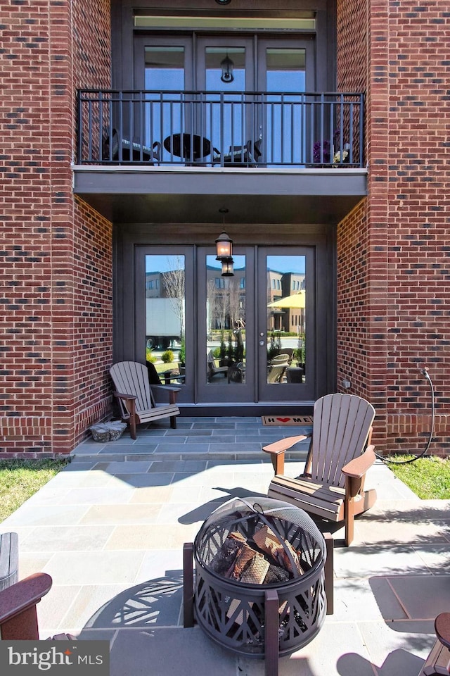 23109 Cottonwillow Sq, Brambleton, VA 20148 - doorway to property featuring french doors, a balcony, brick siding, and a patio area