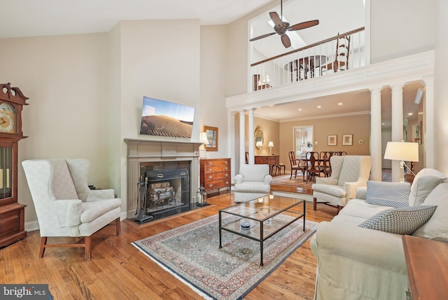 36 Wingstone Ln, Devon, PA 19333 - living room featuring ceiling fan, a fireplace, wood finished floors, ornate columns, and ornamental molding
