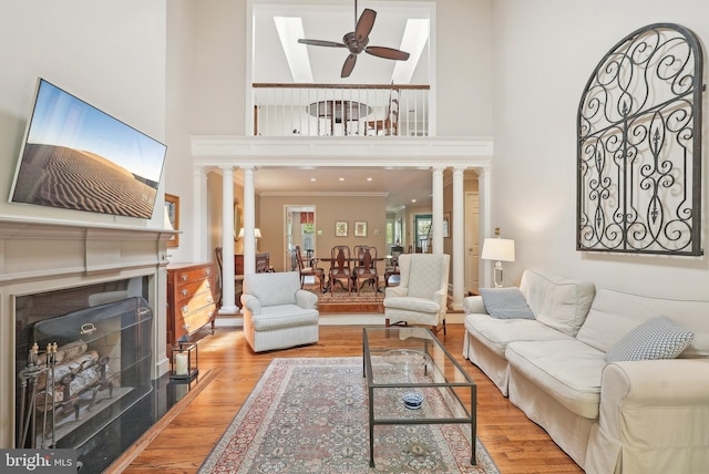 36 Wingstone Ln, Devon, PA 19333 - living room featuring ornate columns, a fireplace, ceiling fan, wood finished floors, and ornamental molding