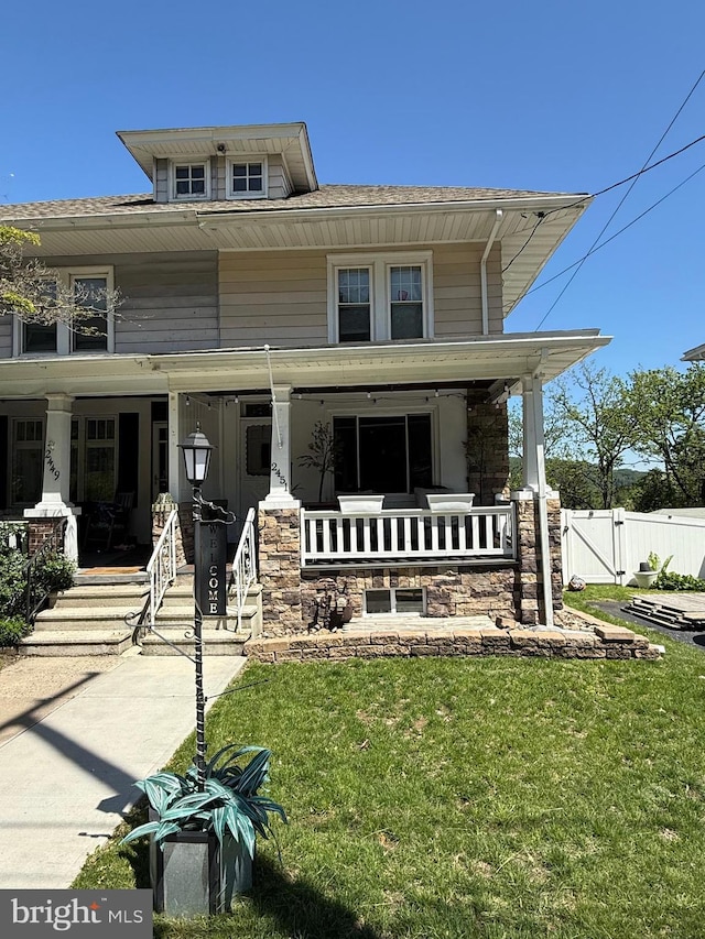 american foursquare style home featuring covered porch, a gate, and roof with shingles