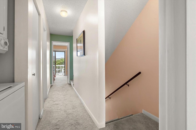 614 Osprey Rd Unit D, Ocean City, MD 21842 - corridor featuring an upstairs landing, light carpet, stacked washer and clothes dryer, a textured ceiling, and baseboards