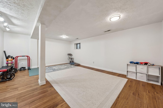 10707 Muirfield Dr, Potomac, MD 20854 - finished basement with a textured ceiling, wood finished floors, and baseboards