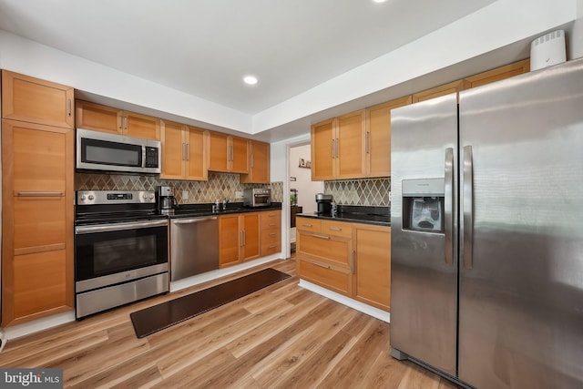10707 Muirfield Dr, Potomac, MD 20854 - kitchen with appliances with stainless steel finishes, dark countertops, light wood-style floors, tasteful backsplash, and recessed lighting