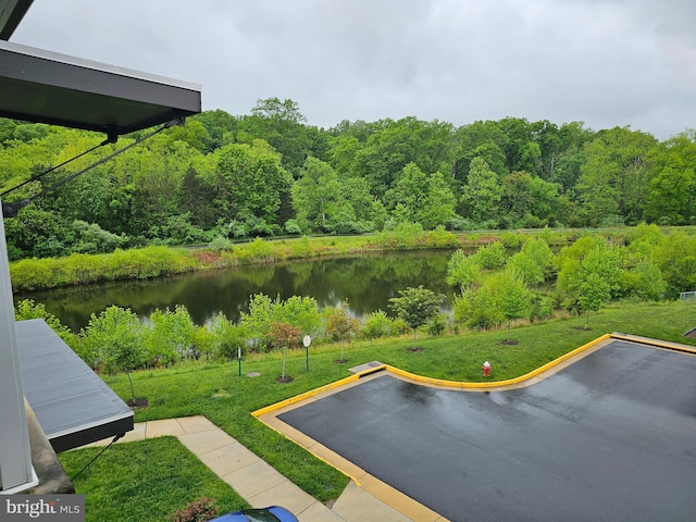 exterior space with a large body of water and a heavily wooded area