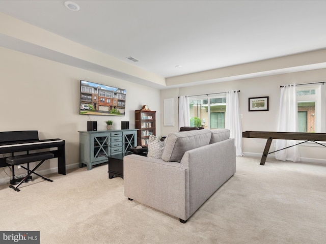 living area with light carpet and baseboards