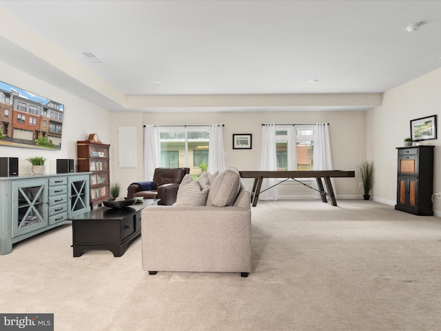 living area featuring light carpet and baseboards