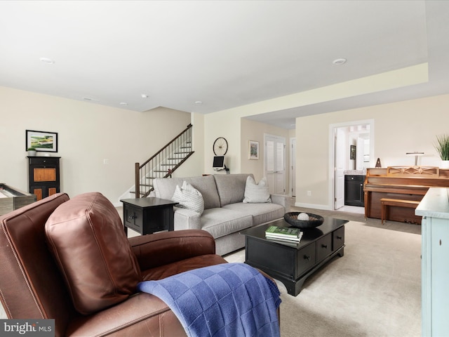 living room featuring stairway and light carpet