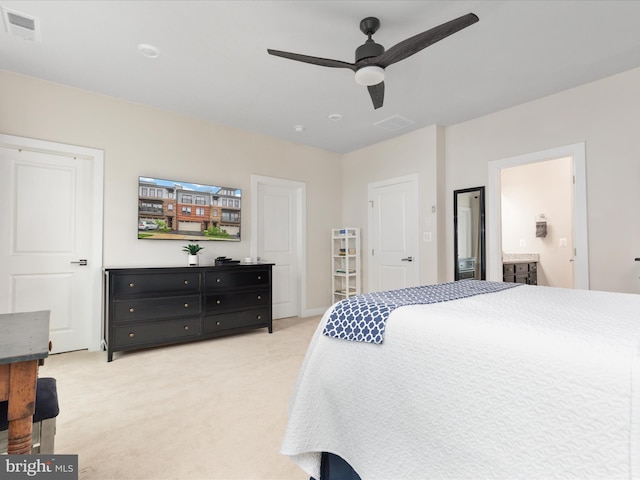 bedroom with light carpet, a ceiling fan, and connected bathroom