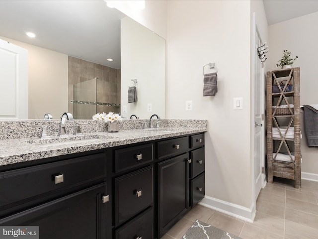 bathroom featuring tiled shower, double vanity, baseboards, recessed lighting, and tile patterned floors