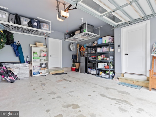 garage featuring a garage door opener and freestanding refrigerator
