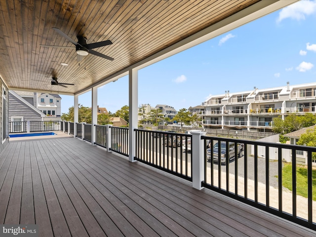 wooden terrace with a residential view and a ceiling fan