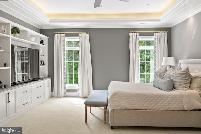 bedroom featuring a raised ceiling, ornamental molding, multiple windows, and light carpet