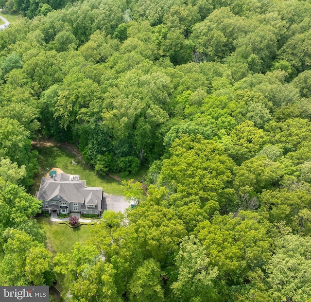 aerial view of property and surrounding area with a heavily wooded area