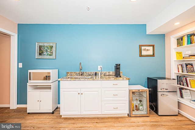 9 Webster Hill Ct, Clarksburg, MD 20871 - kitchen with white cabinetry, light stone counters, freestanding refrigerator, light wood finished floors, and white microwave