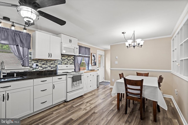 kitchen with white appliances, a sink, wood finished floors, plenty of natural light, and crown molding