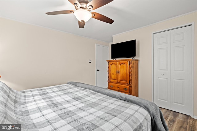 bedroom with wood finished floors, a closet, ceiling fan, and crown molding