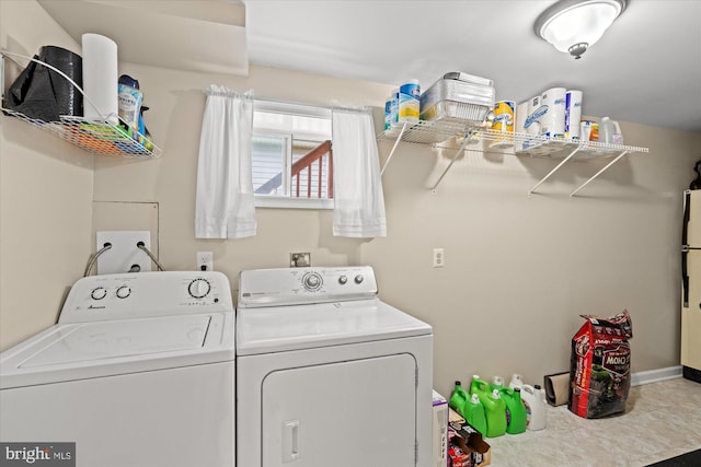 clothes washing area featuring washer and clothes dryer and baseboards