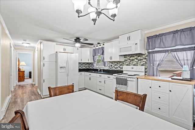 kitchen featuring white appliances, a sink, backsplash, a chandelier, and crown molding