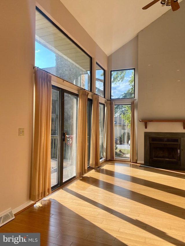 411 Lynetree Dr Unit 12-C, West Chester, PA 19380 - unfurnished living room featuring wood-type flooring, a ceiling fan, a fireplace, high vaulted ceiling, and baseboards