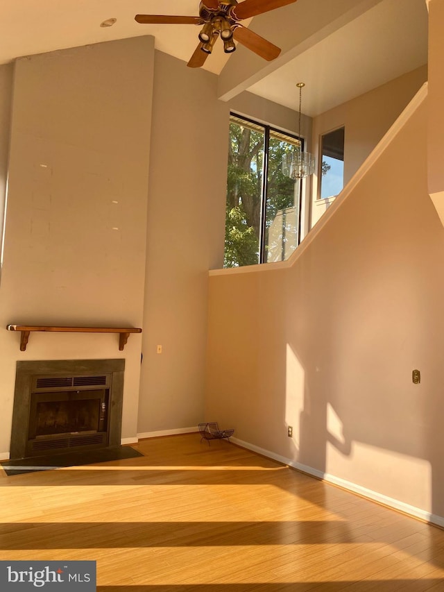 411 Lynetree Dr Unit 12-C, West Chester, PA 19380 - unfurnished living room with wood finished floors, a ceiling fan, baseboards, a fireplace with flush hearth, and a chandelier