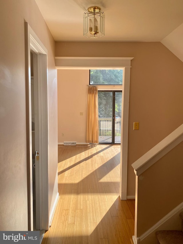 411 Lynetree Dr Unit 12-C, West Chester, PA 19380 - hallway featuring wood finished floors, lofted ceiling, a chandelier, baseboards, and stairs