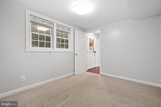 carpeted spare room featuring baseboards